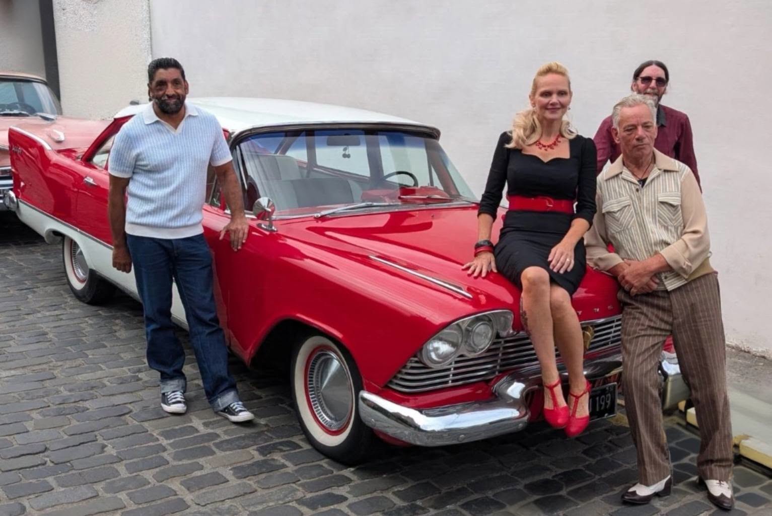 Plymouth 57’s posing beside a red and white Plymouth, with Lorna-Jane seated on the bonnet