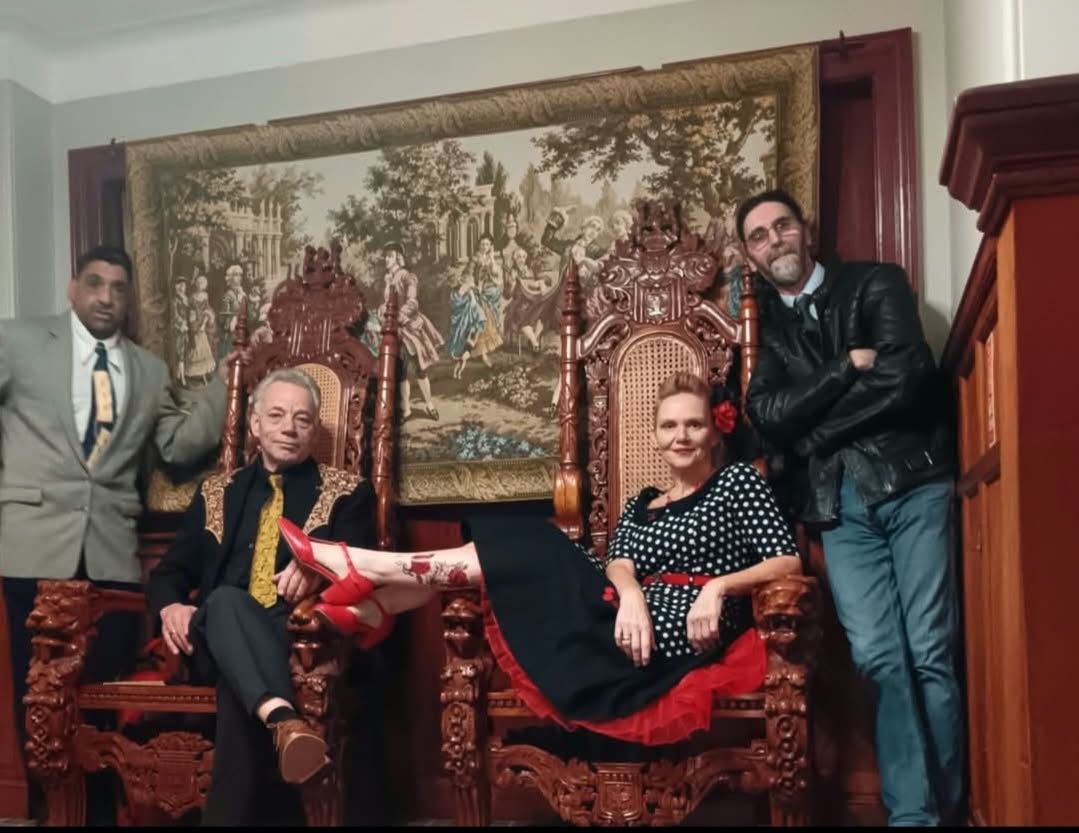 The band posing around two ornate chairs with Lorna-Jane seated in front